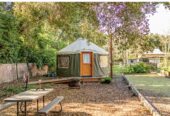 16’ round green Pacific Yurt with tiny fireplace