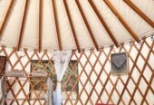 16’ round green Pacific Yurt with tiny fireplace